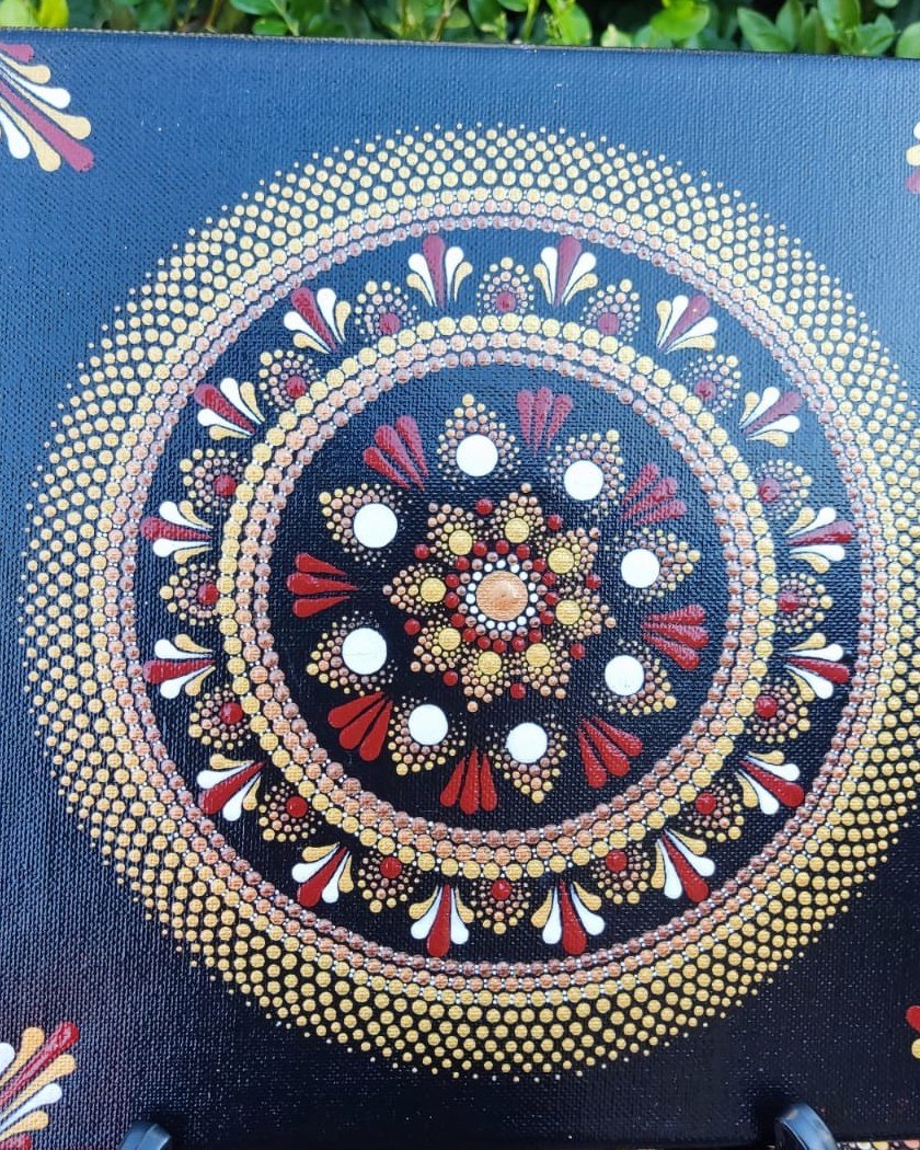 Mandala en pointillés rouge et or peint à la main sur toile noire par Nadine